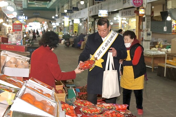 최원철 공주시장이 이날 방문한 전통시장에서 상인으로부터 딸기를 구매하고 있다.ⓒ